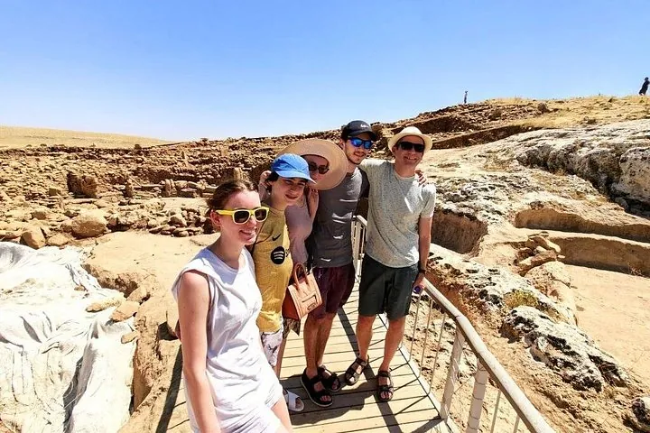 Four travelers on the walkway at Karahan Tepe on a Gobekli Tepe tour from Istanbul by plane, Turkey