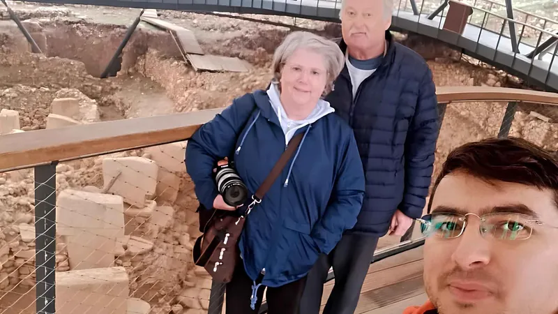 Two travelers and their guide on the walkway above the pillars on a Gobekli Tepe tour from Istanbul, Turkey