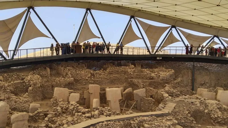 Visitors along the railing above the stone enclosures on a Gobekli Tepe tour from Şanlıurfa, Turkey